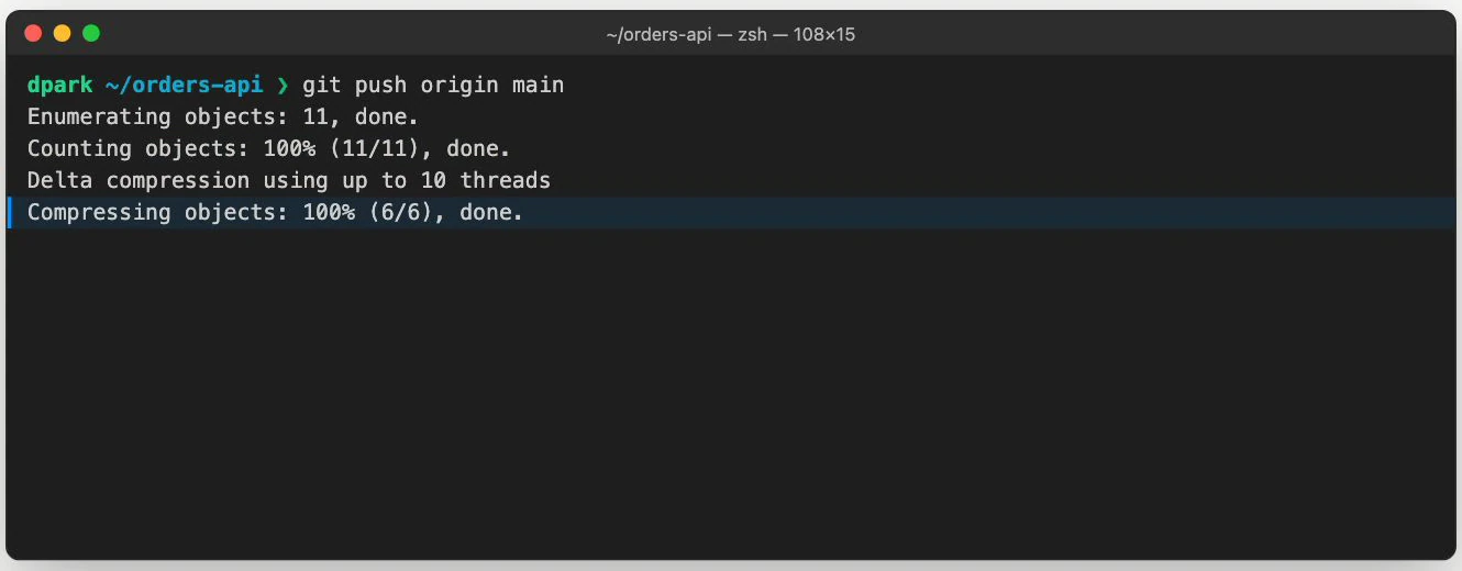 Terminal from a staged git-push lesson with the Compressing objects: 100% line highlighted in blue. The git push origin main command, enumeration, counting, and delta-compression lines remain above it.